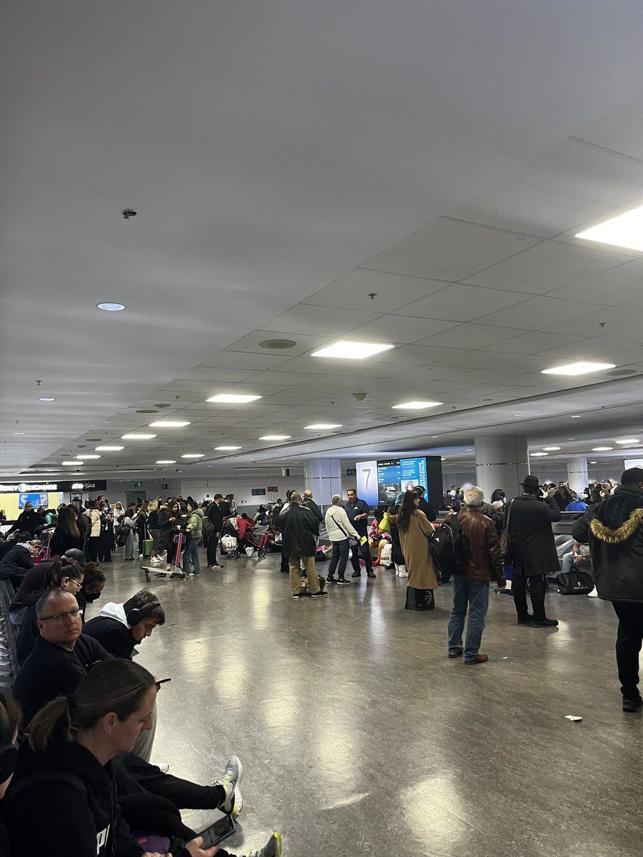kaitlinsparkman's tweet photo. Absolute shit show at @TorontoPearson tonight. Had to wait to get to gate due to lack of ground crew. Then had to wait 45 min to deplane. Now we have been waiting over 1.5 hours and baggage and has not even started. Get it together https://t.co/QEtsbL7uFI