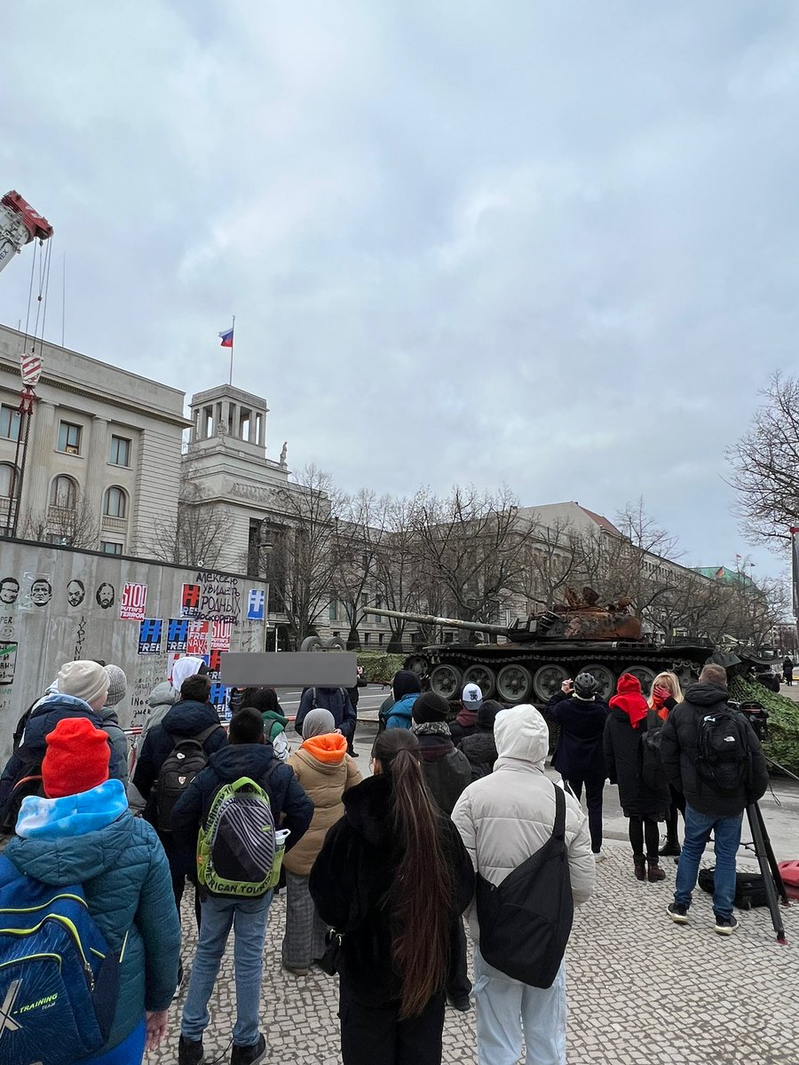Seit der Nacht steht ein im März 2022 zerstörter 🇷🇺 Panzer vor der 🇷🇺 Botschaft in Berlin. 

Als ich dort stehe, kommt gerade eine Gruppe von Schulkindern vorbei, die aus 🇺🇦 geflüchtet sind, wie sie mir sagen. Kurzerhand stellen sie sich neben den Panzer und singen die 🇺🇦 Hymne.