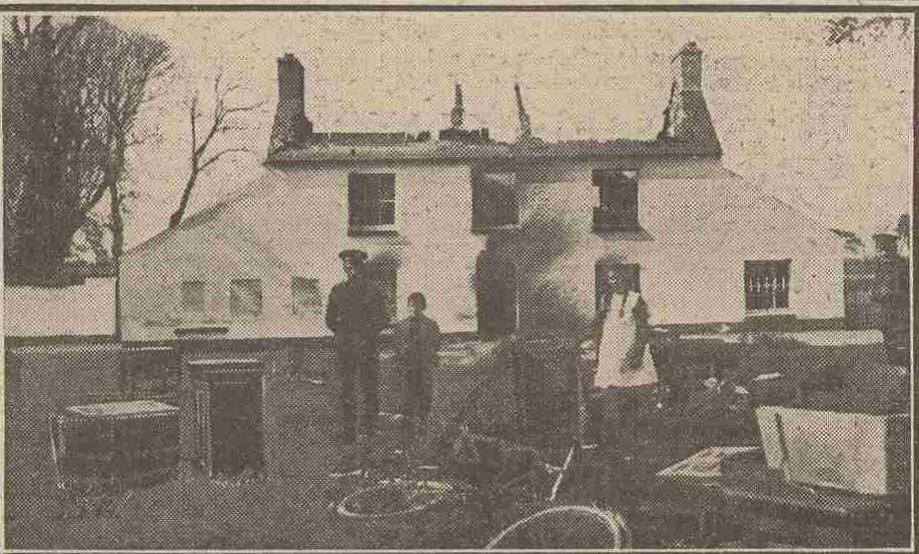 Photo showing the burned shell of Tintern Barracks. The man on the left is RIC sergeant Edmond Larrissy, with his son Thomas Brady and daughter Margaret Mary.  Their furniture on the front lawn was removed from house for them by the local IRA before they set the building alight.