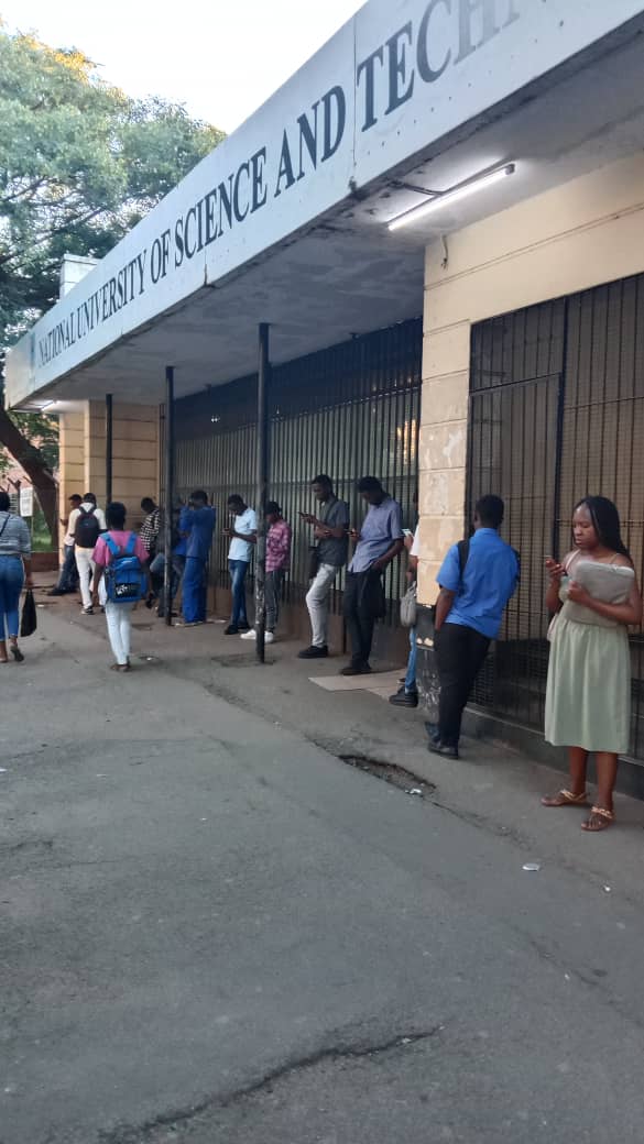 Wataska__'s tweet photo. A handful of the National University of Science and Technology students stand by the university's town library in the CBD to access wifi. The library does not have enough space to accommodate all students which limits flexible reading space.
#NUST https://t.co/xPXcBuSmm5