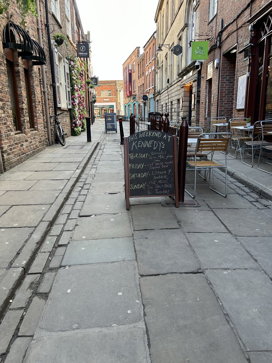 Little Stonegate. Blatant abuse of their licensing conditions by Kennedy’s. Spread of their furniture plus A- Boards &amp; bicycle chained to drainpipe + bollards has turned it into the latest assault course for disabled people. Enforcement please <a href="/CityofYork/">City of York Council</a> !