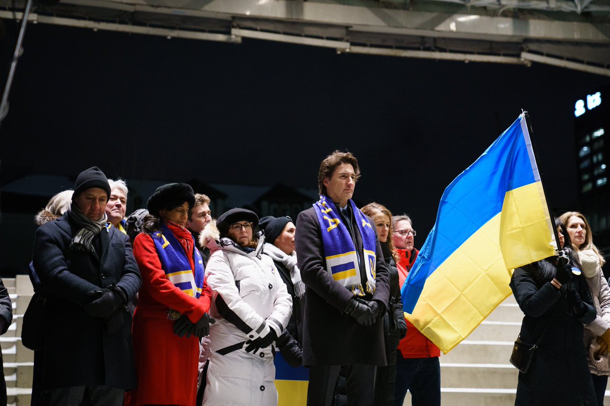 JustinTrudeau's tweet photo. A year ago, Ukrainians woke up to the horrors of war. But that day and every day since, they’ve stood strong. And we’re standing with them. Together with the @ukrcancongress, we came together to show our support – and to remind Ukrainians that we’ll always be here for them. https://t.co/e5KSZudXFW