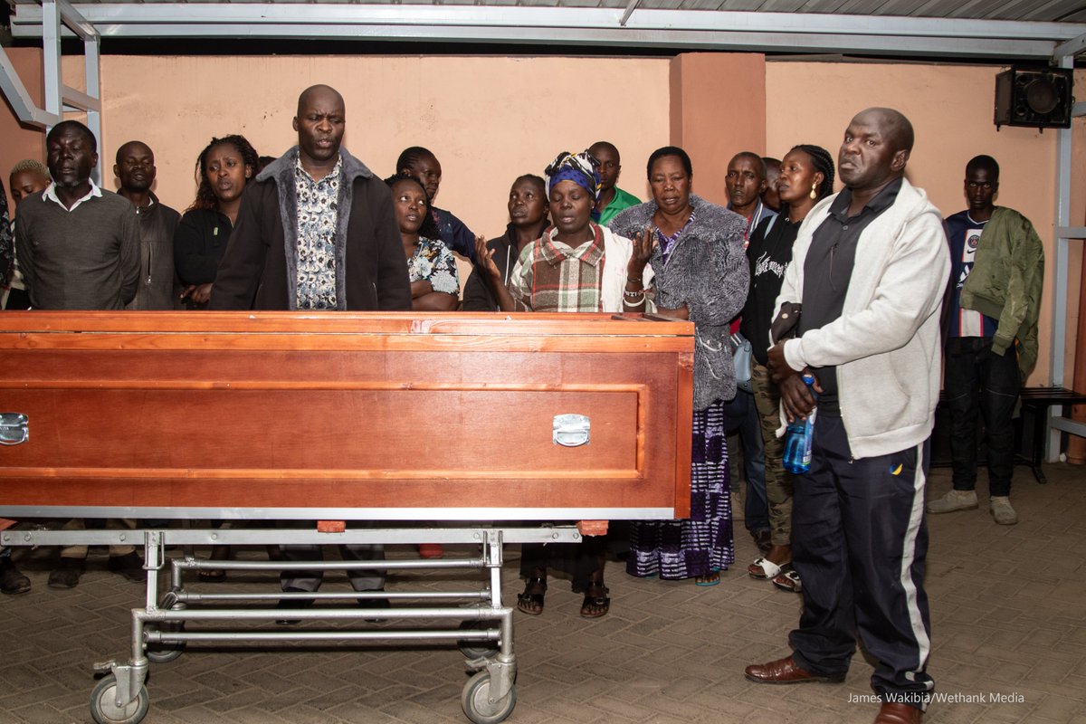 wethankmedia's tweet photo. Mourners pray beside the casket containing the body of Judith Adhiambo at a morgue when it arrived from Saudi Arabia. Judith is reported to have died under unclear circumstances. Despite claims that Judith Adhiambo tripped in the bathroom..... https://t.co/E5eLPWlIYp
