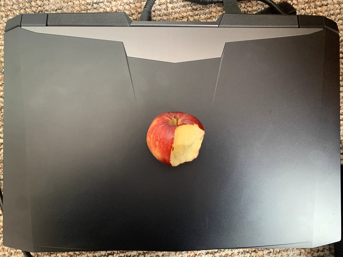 A windows laptop with an apple on top with a bite out of it