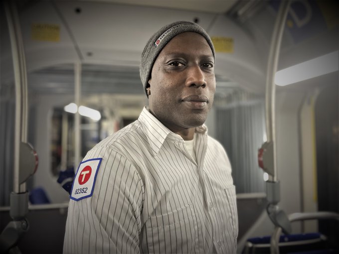 Ambrose Y., in uniform, standing in a bus.