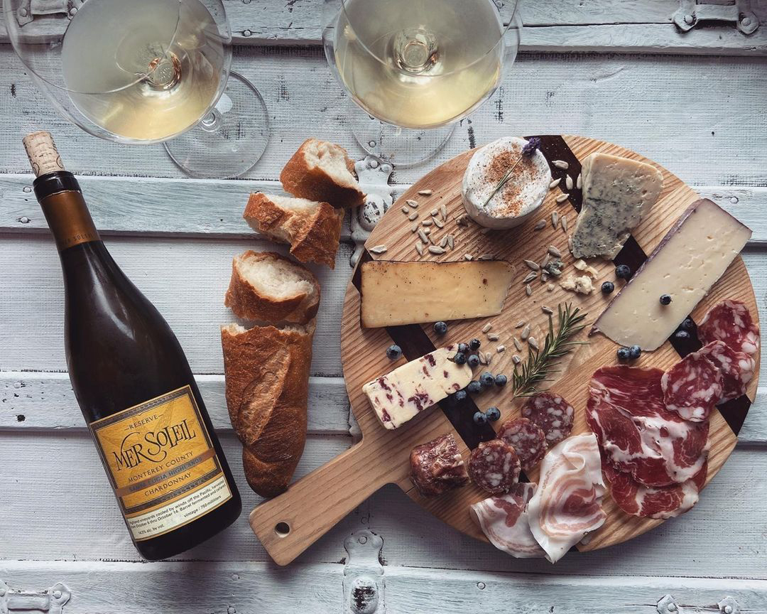 Enhance your next gathering with a spread that's sure to impress. An assortment of charcuterie, creamy and hard cheeses with a chilled bottle of Mer Soleil Chardonnay is an absolute crowd pleaser.