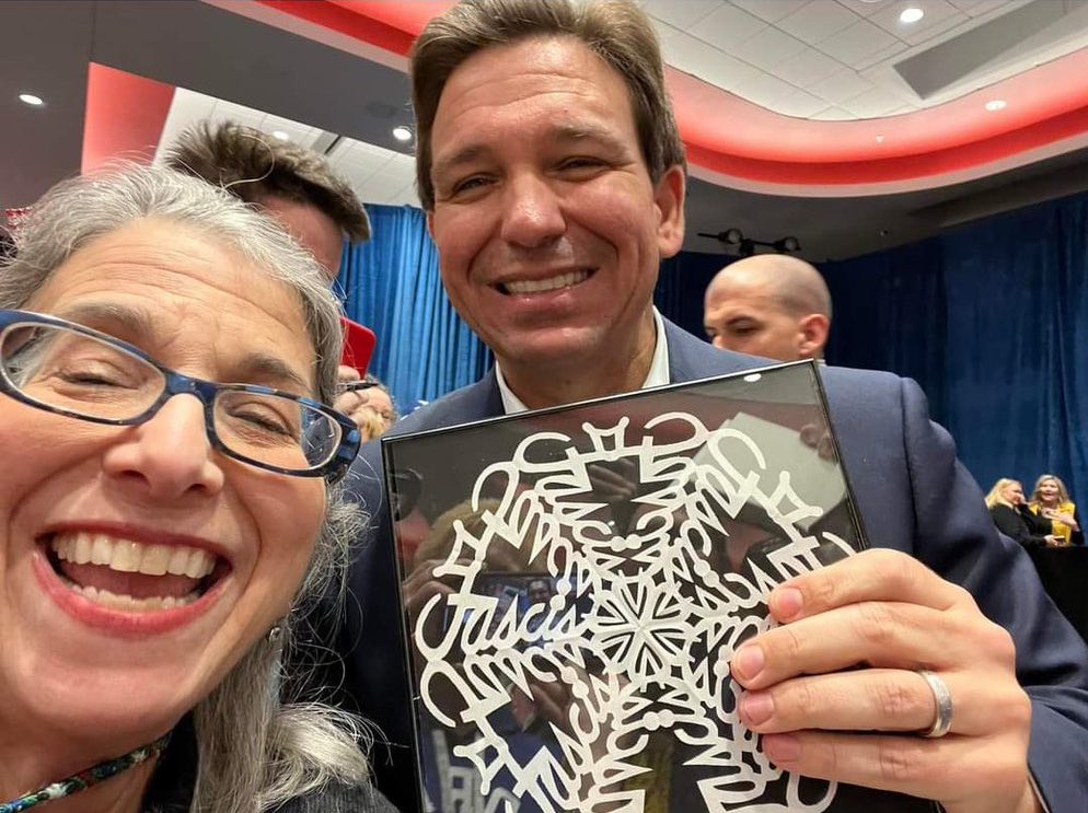 SteveGoffman's tweet image. At a Republican political rally in Davenport, Iowa today someone gave @GovRonDeSantis and @IAGovernor Kim Reynolds a handmade “snowflake” with the word "Fascist" secretly embedded in it.