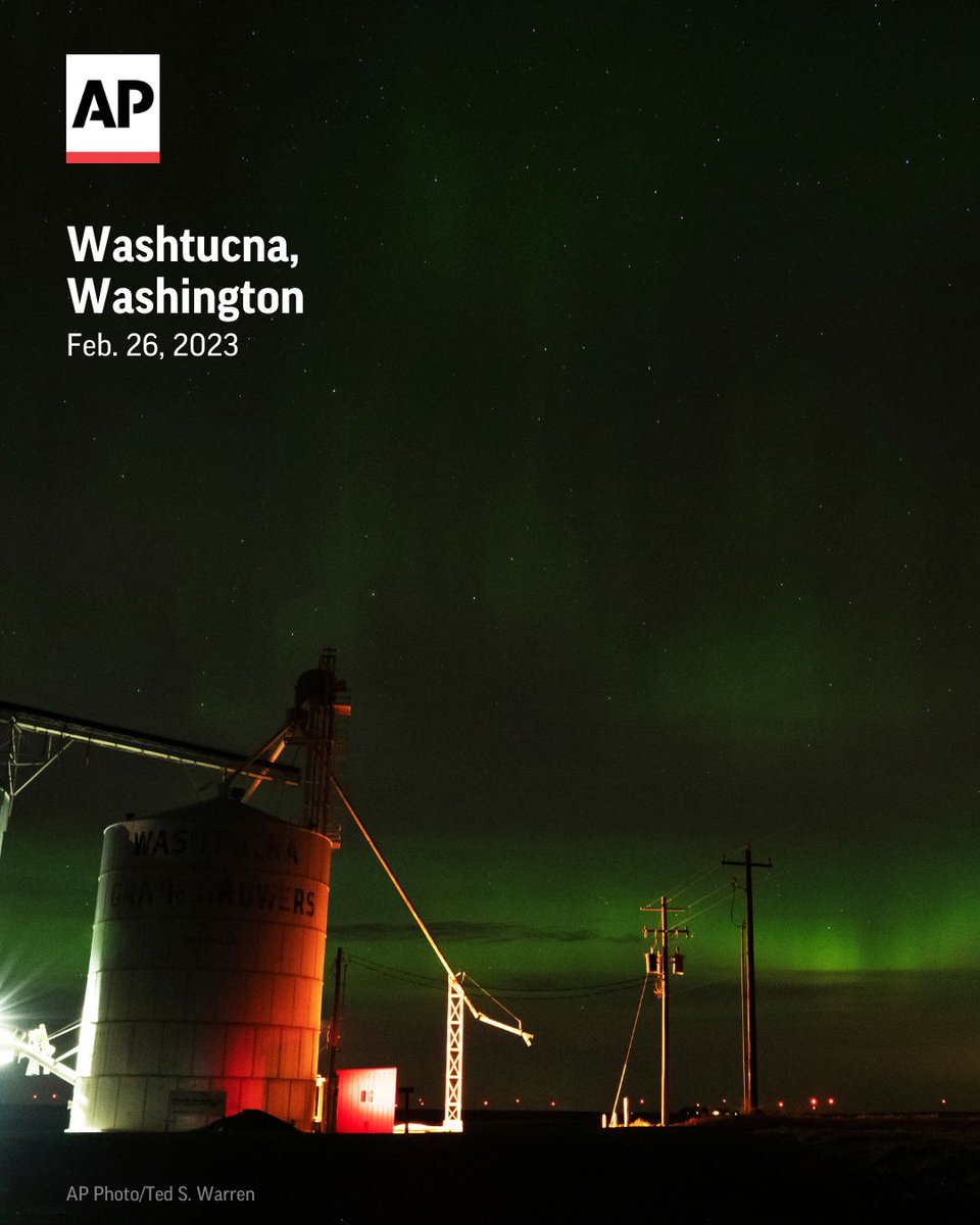 AP's tweet photo. An aurora borealis, also known as the northern lights, is seen in the night sky next to grain elevators near Washtucna, Washington. https://t.co/DsLLYB4gSE