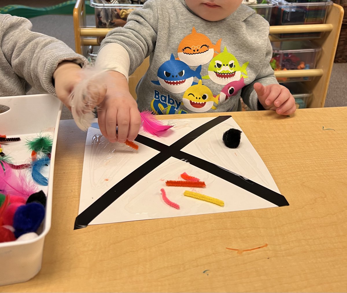 kcce_yr's tweet photo. The toddlers at Carnegie CCC are wrapping up the artist of the month for February; Romero Britto by creating art using black tape, pompoms, cut up pipe cleaners, feathers and sequins with glue to make these 3D patterns. https://t.co/vKMXGe1bMu