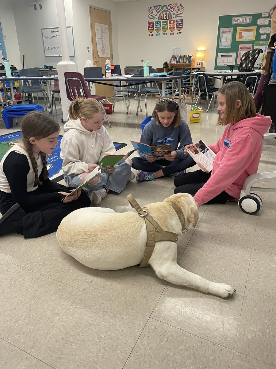 EES grade 4 students take turns reading to Cisco.