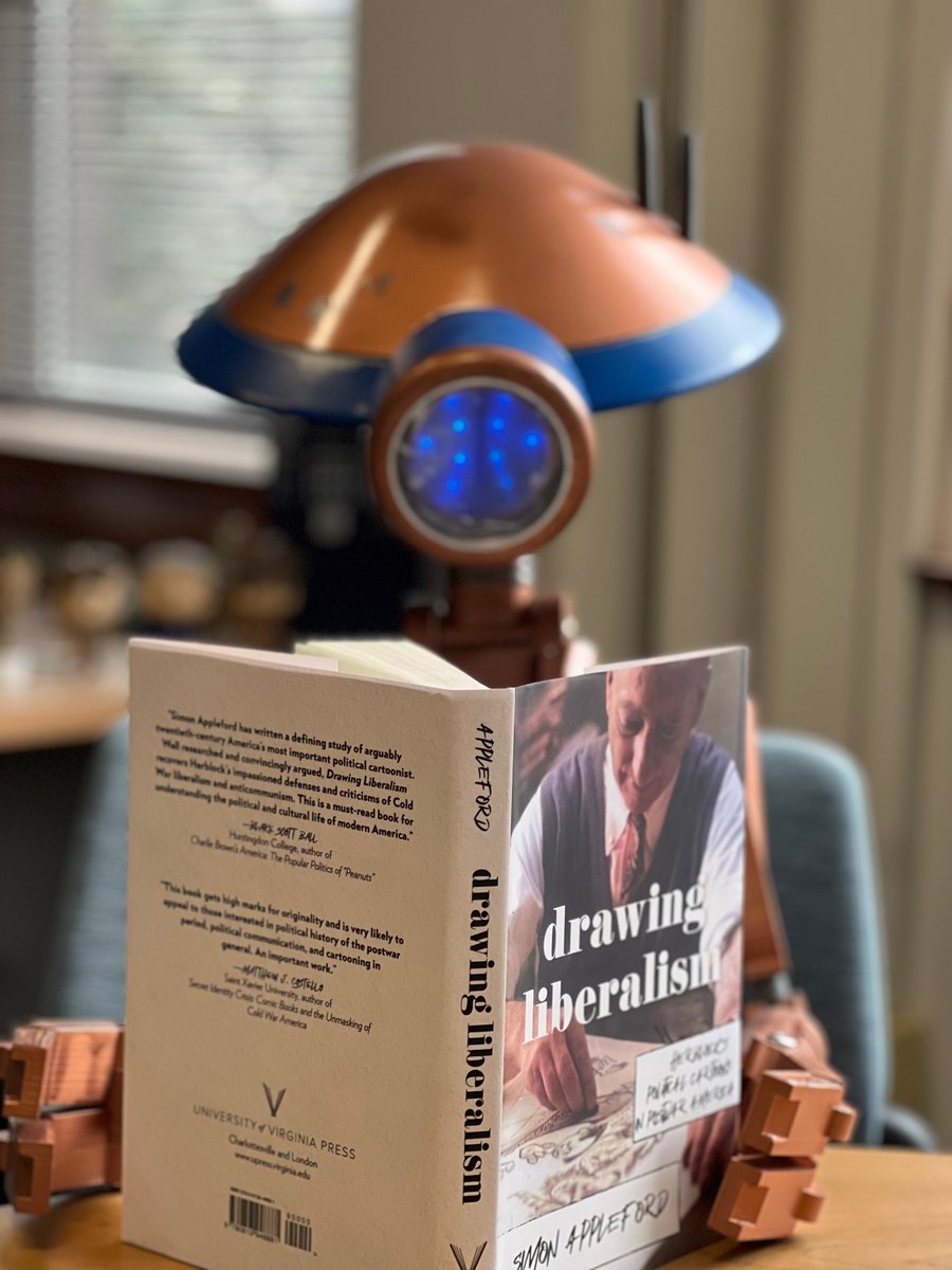 My #pitdroid is enjoying his copy of _Drawing Liberalism: Herblock's Political Cartoons in Postwar America_ on #worldbookday. #comicsstudies #herblock #WorldBookDay2023