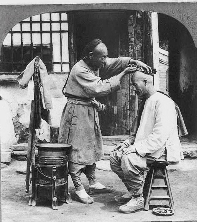 Barber with a customer, Peking, China, c1902. Prints and Photographs Division, Library of Congress.