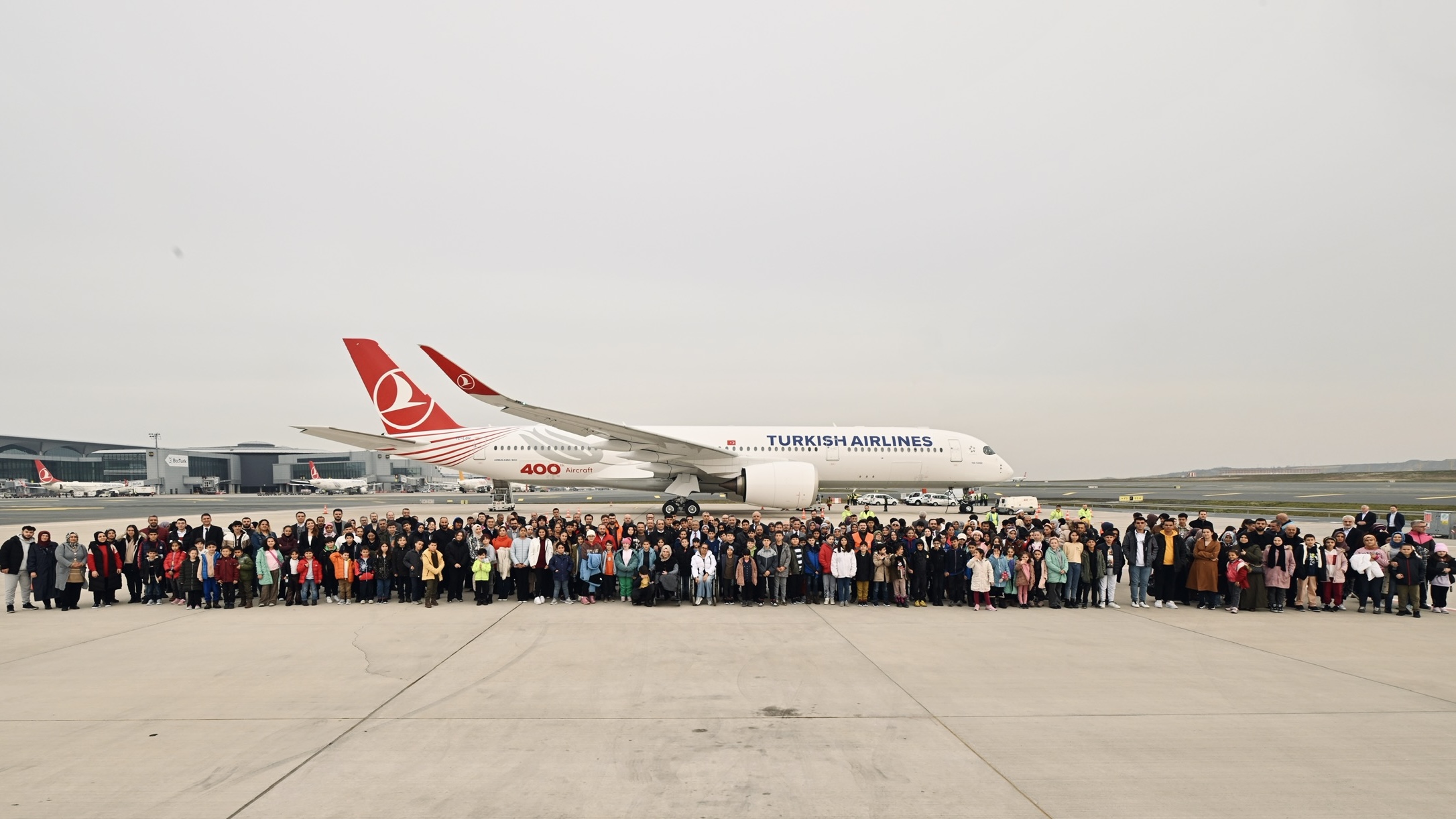 Türk Hava Yolları’nın Tek Yürek adlı 400’üncü uçağı İstanbul Havalimanı apronunda duruyor. 169 depremzede çocuk ve 106 anne baba, Türk Hava Yolları yetkilileriyle birlikte uçağın yanında bir arada durmuş, objektife bakıyor. Poz veren grubun ön sıralarında çocuklar, tekerlekli sandalyede iki kişi fark seçiliyor.Sağ profilinde hizalanan depremzedeleri kanatları altına almış hissi uyandıran A350-900 tipi uçağın ön gövdesinde mavi harflerle “Turkish Airlines”, arka alt kısmında kırmızı renkle “400. Aircraft” yazıyor. Uçak gövdesinde gri bir Türk lalesi, kuyruğa doğru 7 kırmızı ince çizgi yer alıyor. Kuyruğunda ve kanat ucunda kırmızı zemin üzerinde kanatlarını açmış beyaz bir yaban kazı figüründen oluşan Türk Hava Yolları logosu bulunmakta. 