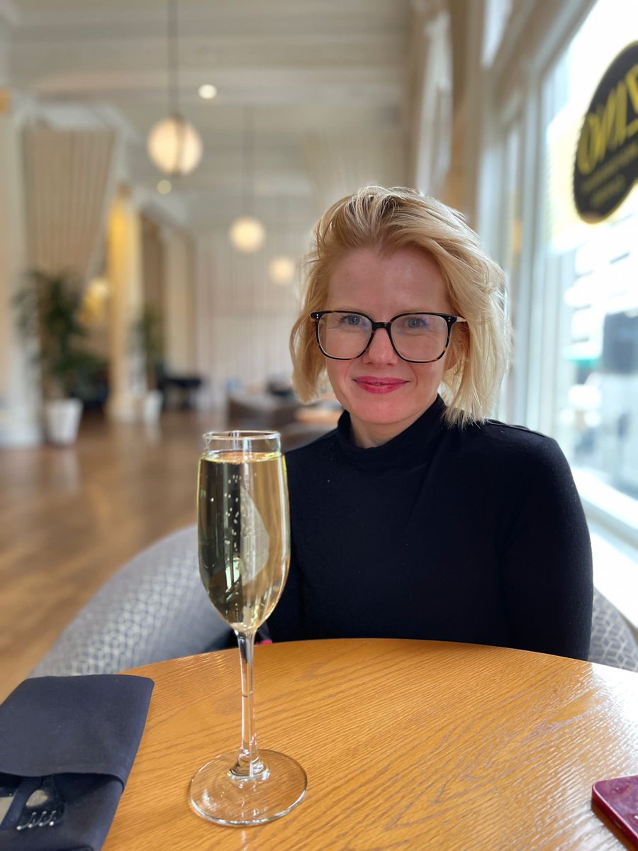 Woman sitting at a table with a glass of champagne