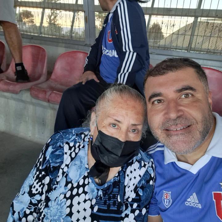 DaniAlegria_'s tweet photo. Aclaro: El video que se viralizó me lo hicieron llegar por Instagram, y me corrige su familia que la gran mujer bullanguera que aquí ven tiene 73 años, no 85 🫣 perdón! Acá una imagen de ella en Curicó con su hijo. 

¡Aguante la U!! Ejemplo a seguir 💙 https://t.co/Soz83rmOLS