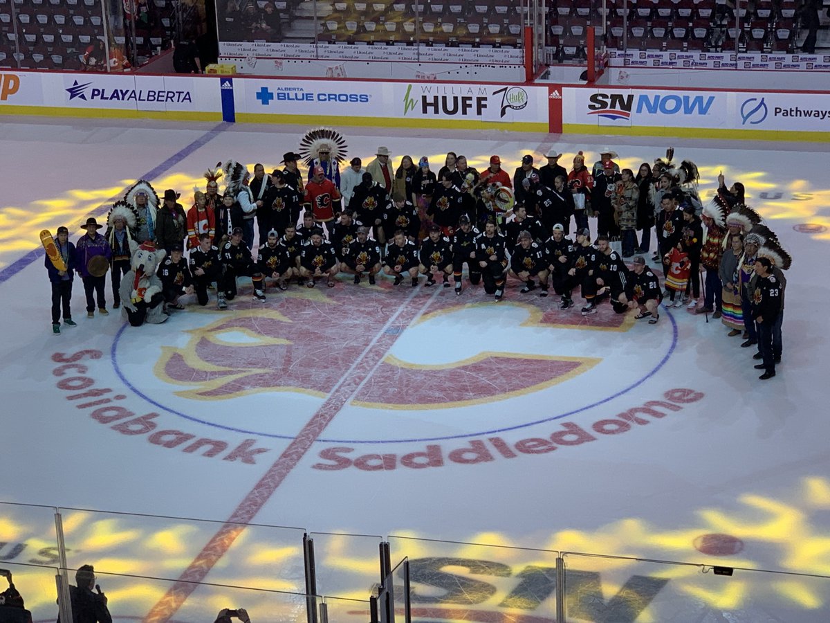 RickTulsie's tweet photo. End of the #Flames #IndigenousCelebration game. Some of the dignitaries were invited on #NHl ice for a pic with the players. So cool, memories for a long time for those folks. #Calgary Saddledome #EventGuy #fun @TourismCalgary lots of visitors from out of town. https://t.co/SLiMFFPqUK