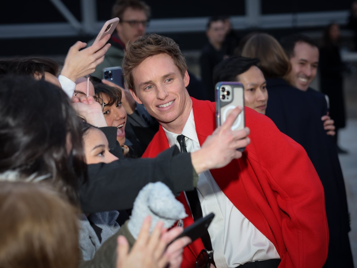 Aww! Elle Fanning and Eddie Redmayne (with wife Hannah Bagshawe) showed their sweet natures as they interacted with fans ahead of the Alexander McQueen show during Paris Fashion Week. (Plus, how incredible are their looks?!) 😍