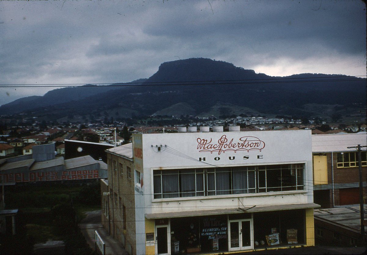 eric_riddler's tweet photo. #FoundSlideHoliday MacRobertson House, soon-to-be-closed distribution point of Wollongong’s supply of Freddo Frogs and Cherry Ripe chocolate bars, stands out against the backdrop of Mount Keira, Tharawal country, circa 1960 (photographer unknown) https://t.co/htSK0onvYl