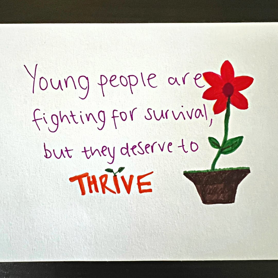 Photo of a piece of paper that reads 'young people are fighting for survival, but they deserve to thrive' with a picture of a flower.
