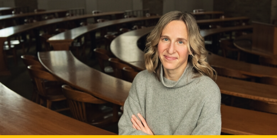 Prof Leah Litman smiles with her arms folded in a Michigan Law classroom