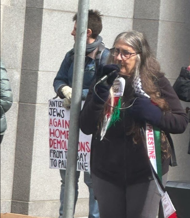 AnarchoZionist's tweet photo. JVP's Lynn Gottlieb does her version of a #Purim Shpiel in front of @IsraelinSF , accusing Israel of genocide, ethnic cleansing, and the collapse of bee colonies worldwide https://t.co/F1WS9dp7gx