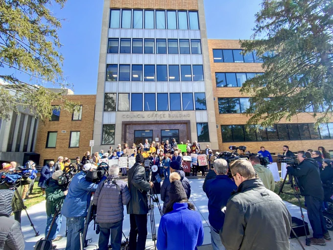 Photo from behind the row of media cameras pointed at the press conference in front of the Council building
