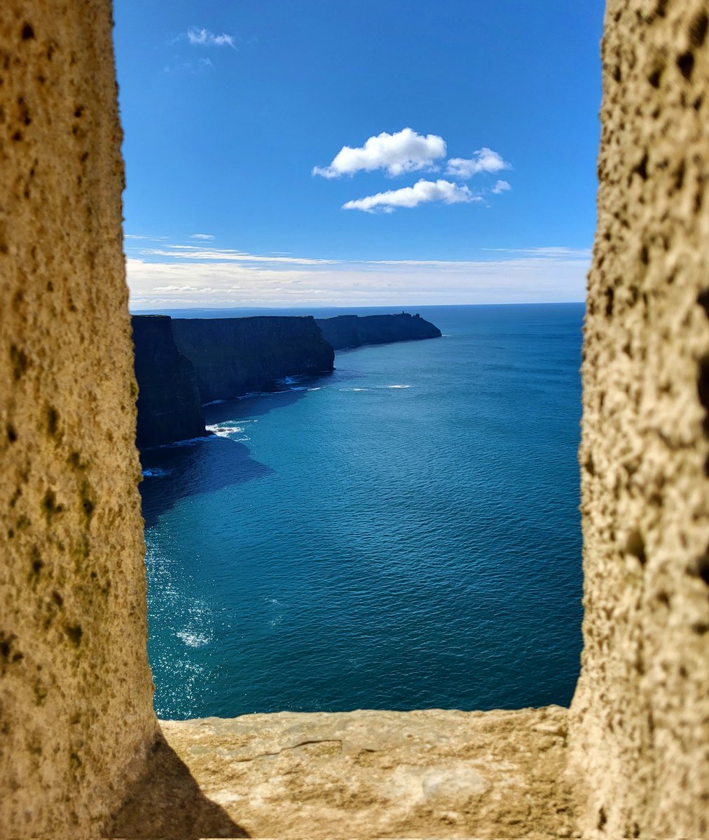 Shadowy cliff faces and small fluffy clouds - the view from O'Brien's Tower at the Cliffs of Moher two days ago. County Clare, Ireland.