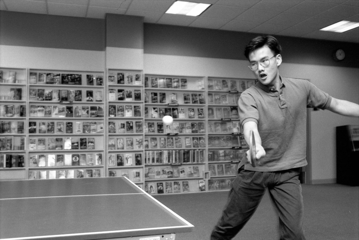 A student prepares to hit the ping pong ball in the AMU's game room, 1991. On the wall in the background are VHS movies available for rental; at the time, a student could rent a VHS or Nintendo system along with a large selection of titles from the union.
- MU Archives