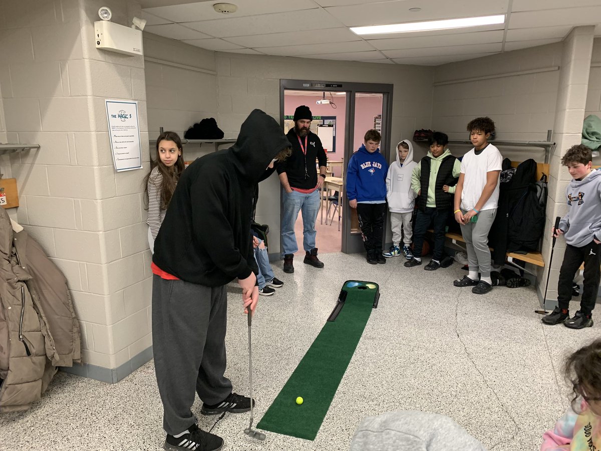 JulieRuberto's tweet photo. How fun is this?!!! Mr. White’s gr 7/8 Ss had to sink a putt to get into class! Even staff got in on the fun! Lots of laughs and a great opportunity to build relationships. Essential Conditions of Learning. @BonaventurePS @wendymacinnis1 @TrusteeMLarsen https://t.co/lHKWfJ4AA0