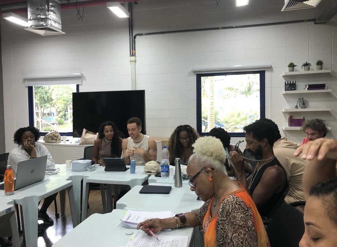 oxentepipoca's tweet photo. A mesa de leitura da 2ª temporada da ÓTIMA 'Encantado’s', série fruto da oficina de humor para roteiristas negros da Globo, já começou.

Criada por Renata Andrade e Thais Pontes, a trama segue irmãos que herdam um mercado, onde de noite vira quadra de uma escola de samba. 🇧🇷 https://t.co/i6CKUMHaCg