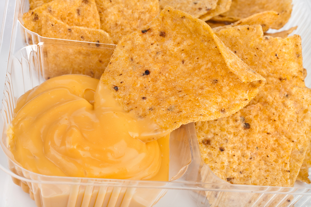 Tortilla chips and a small amount of nacho cheese sauce.