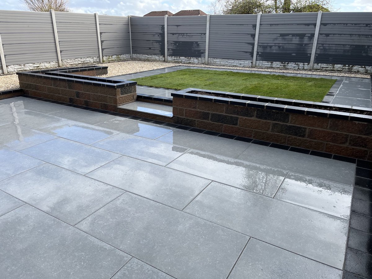 Our latest completed rear garden landscaping project in Prestwick. ⁦@MarshallsGroup⁩ Symphony Classic Porcelain paving in Blauw, bordered with Savanna Charcoal.Tegula Traditional walling built planters with Savanna coping. Cotters Gold stones &amp; real lawn turf, gate &amp; screen