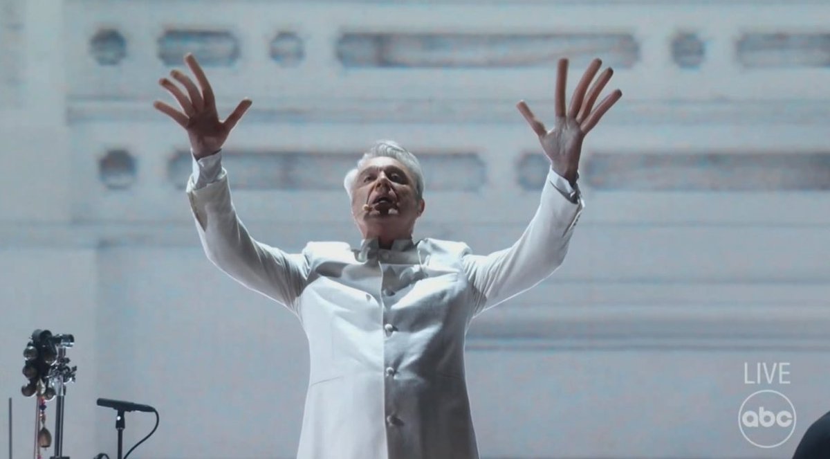 vulture's tweet photo. David Byrne hot dog fingers #oscars https://t.co/oycZG6A5Nh