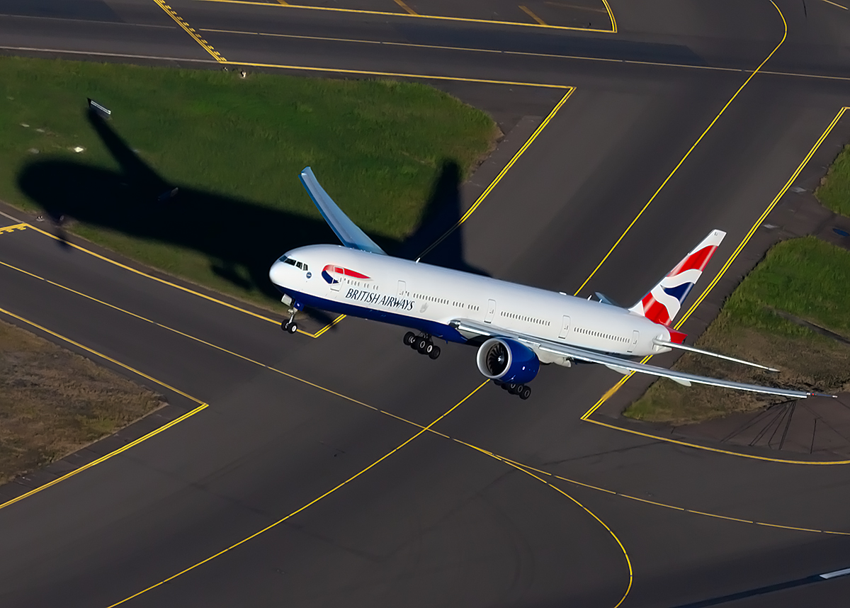 Biggles787's tweet photo. This is @British_Airways @BoeingAirplanes 777-300/ER G-STBJ casting a long shadow while departing RWY 34L at #SYD in 2014. #aerialphotography #Planespotting https://t.co/HhN0zB3DIo