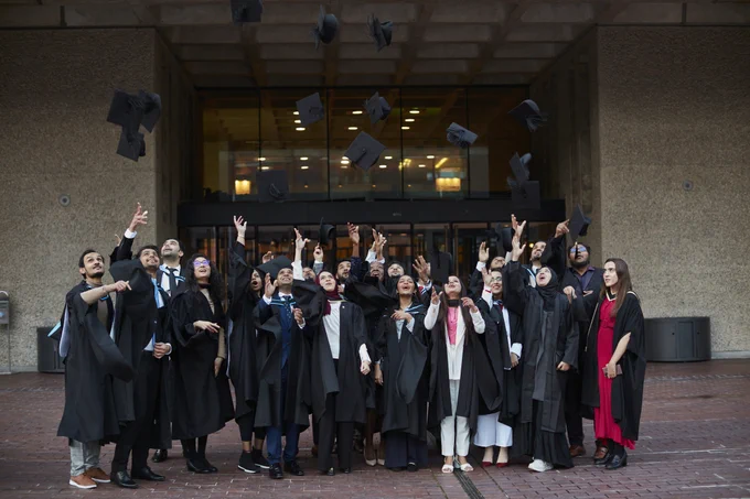 A selection of students throws their hats to celebrate graduation.