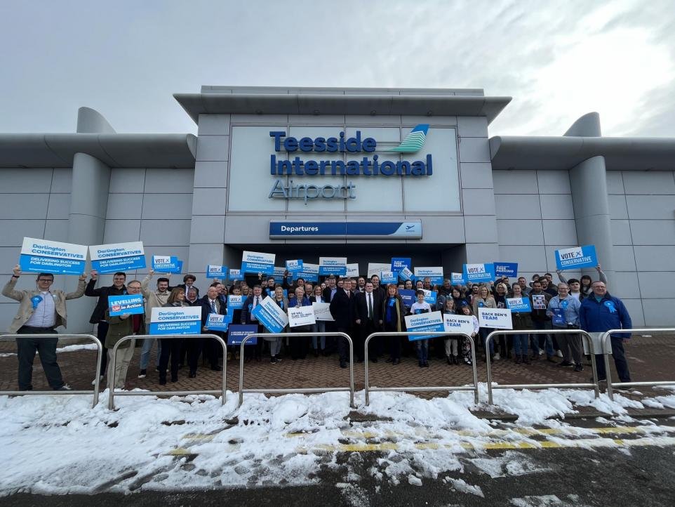 ThisMarkA's tweet photo. Thanks to The Northern Echo for this belter of a picture. Darlington tories starting their campaign. Not in Darlington however, though right where they should be. Asking for re election under a sign that reads  'Departures.' We can only live in hope. #toriesout https://t.co/Yu5zDFbi5J