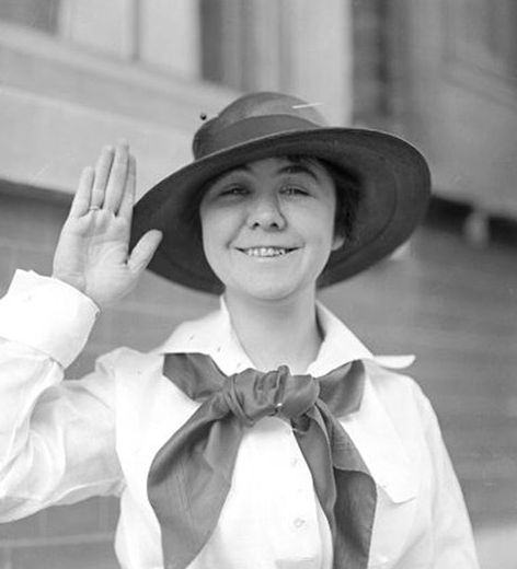 Female sailor dressed in uniform giving a salute. 