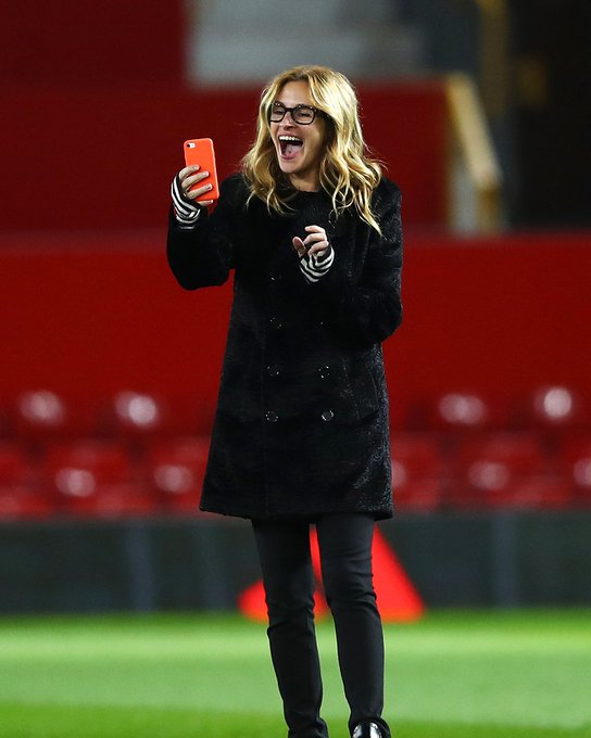 Actress Julia Roberts takes photos on the pitch after a game at Old Trafford.