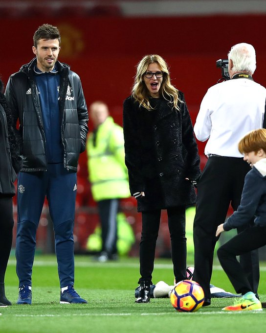 Actress Julia Roberts takes photos on the pitch with Michael Carrick after a game at Old Trafford.