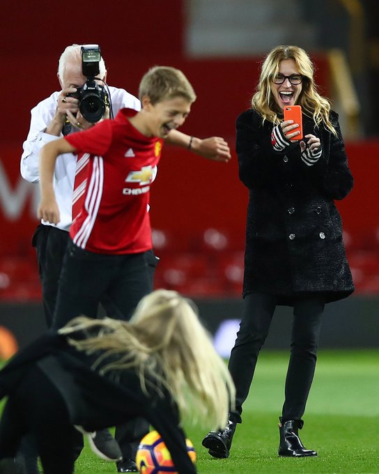 Actress Julia Roberts takes photos on the pitch after a game at Old Trafford.