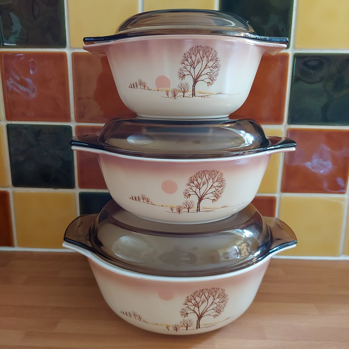 HummingLeftBird's tweet photo. Here's a rare trio of Pyrex England Autumn Moods pattern Casserole Dishes. If you look closely at the pattern on each one, the sun is in a different position. Either sunset or sunrise. #vintageshowandsell https://t.co/nMMeMhUZMm