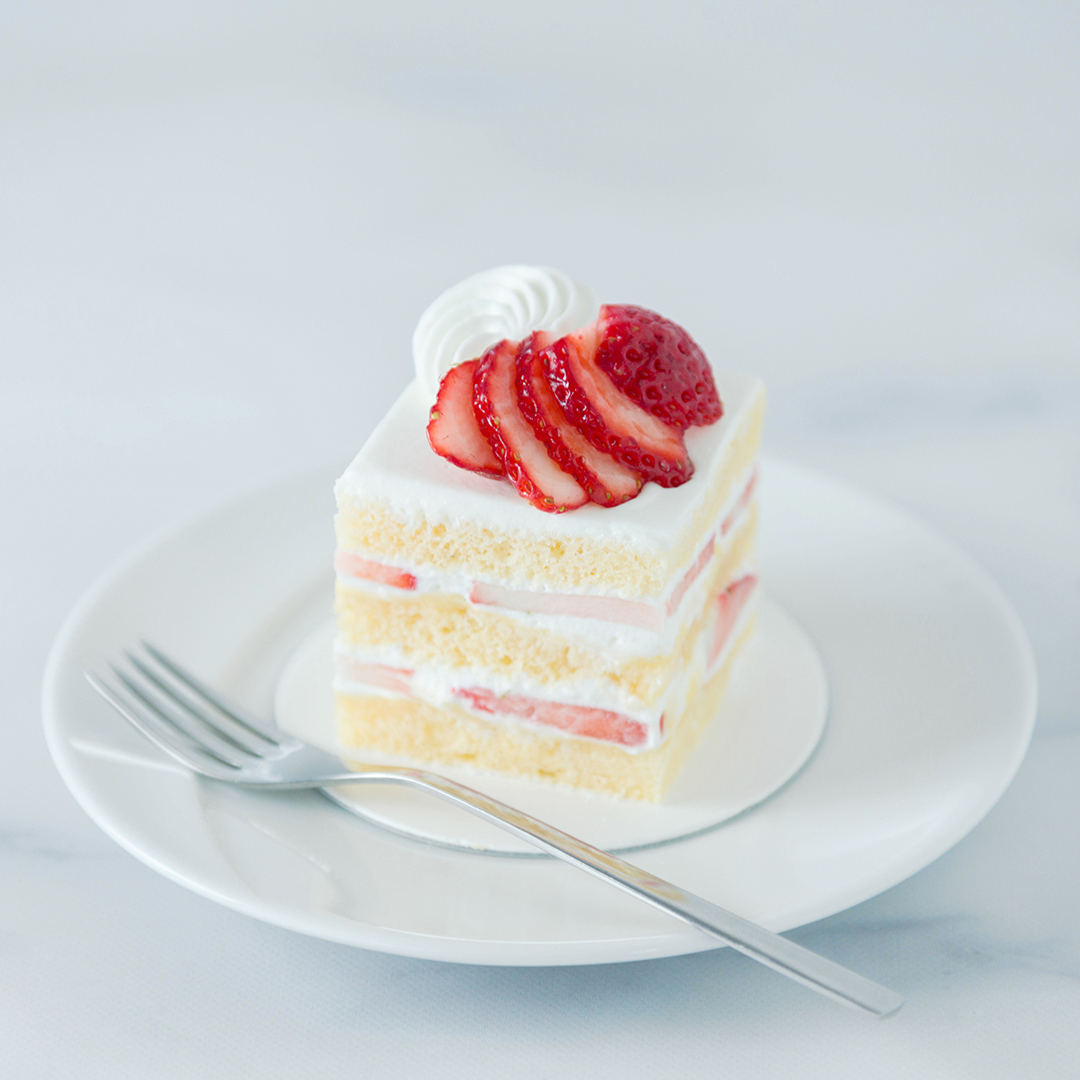 本日3/16(木)より「苺のショートケーキ」を販売します。
旬の苺の甘酸っぱさと、各層に挟みこんだ濃厚なカスタードクリームのコク、ほんのりと香る洋酒のアクセントが絶妙に合わさります。生地と生クリームが一体となって消えゆくような、他にはない味わいと食感が楽しめるショートケーキです。