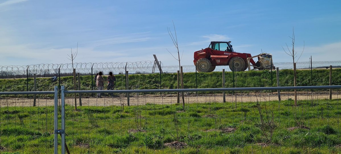 lessoulevements's tweet photo. Installation de barbelé en cours devant la SEV17, la #mégabassines à Mauzé-sur-le-mignon. On pourrait y voir une image dystopique de l'accaparement de l'eau en pleine #sécheresse, mais les irriguants plantent aussi une haie toute mignonne entre deux rangées de grillages 🌿 https://t.co/fljDCqZKew