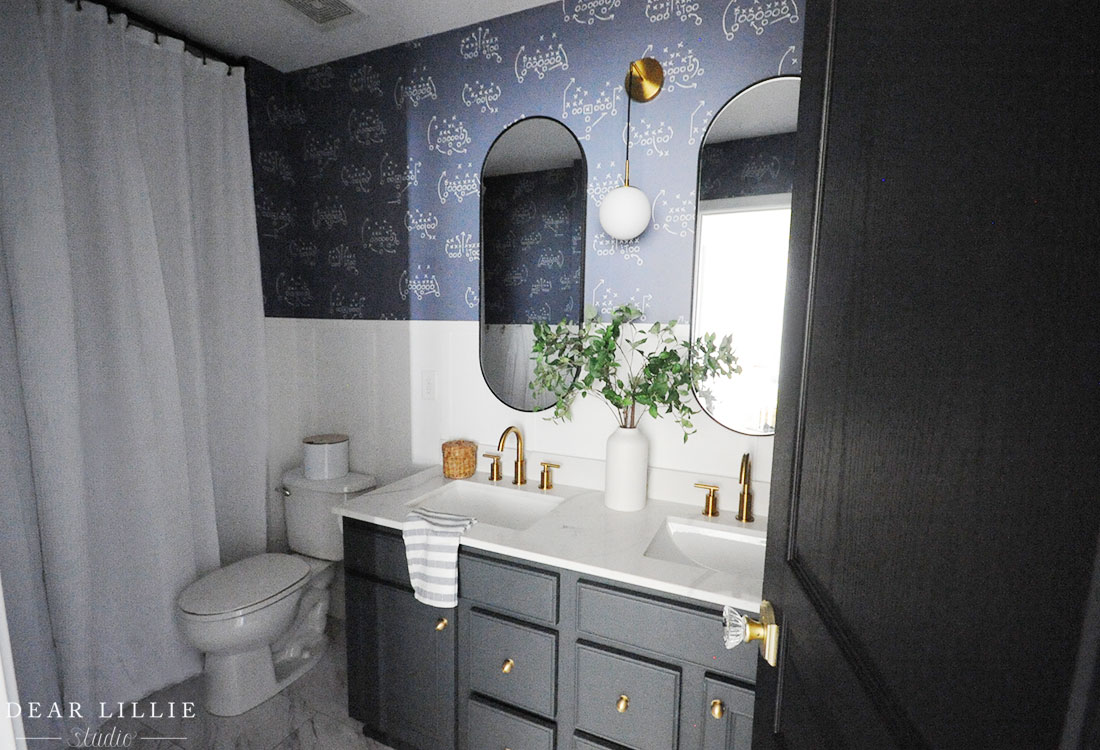 Lola’s Bathroom Makeover with Board and Batten and Football Wallpaper dearlilliestudio.com/bathroom-makeo…