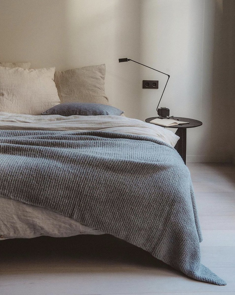 Pure linen bedding in neutrals like flax and sea shell layered with a grey Alpaca knit blanket and slate cushion. Shop the collection at bymolle.com