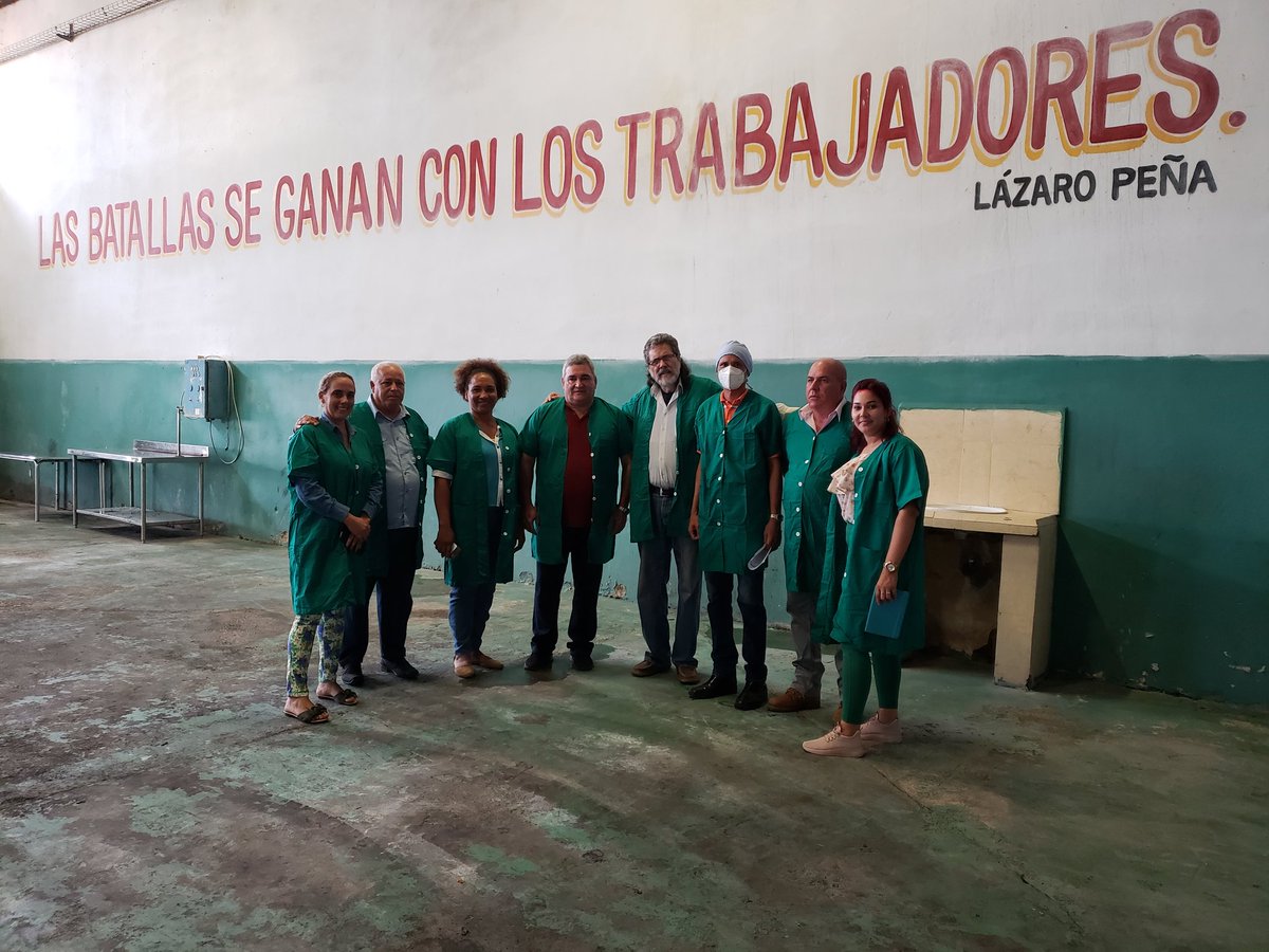 Danielys y yo recorremos instalaciones d la Empresa Agroindustrial Enrique Troncoso, en el Consejo Popular Ceferino Fernández Viñas. En la pared, una frase d Lázaro Peña: "Las batallas se ganan con los trabajadores". #YoVotoXTodos #MejorEsPosible