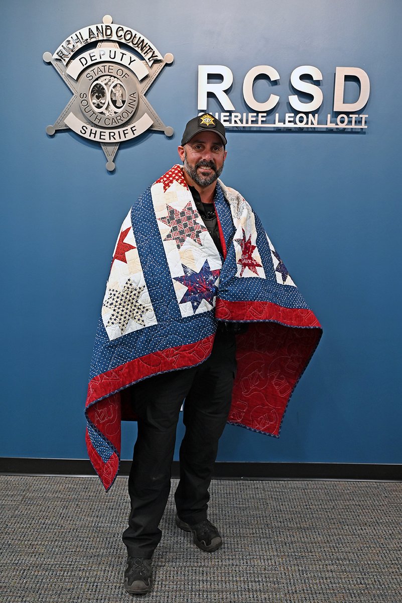 RCSD's tweet photo. Today Dep. JoAnn Gibson presented Cpl. Kenny Fitzsimmons with a Quit of Valor that she made. Quilts of Valor are awarded to a Service Member or Veteran who has been touched by war. โค๏ธ Cpl. Fitzsimmons is a former U.S. Army infantry NCO with deployments to Iraq & Kosovo. ๐บ๐ธ https://t.co/8EclhTossI