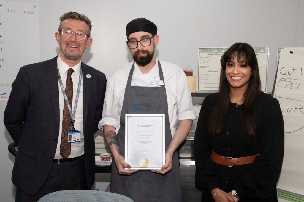 Nicklee100871's tweet photo. Fantastic surprise for Andy Berry receiving his apprenticeship distinction level 4 certification from Philip Shelley FIH & Neely Mozawala yesterday. UHL E&F team are very proud of you! #nhs #team #chef #culinary #hospitals #apprenticeships #careerdevelopment #TeamUHL #smileandy https://t.co/uGNF03fsqF
