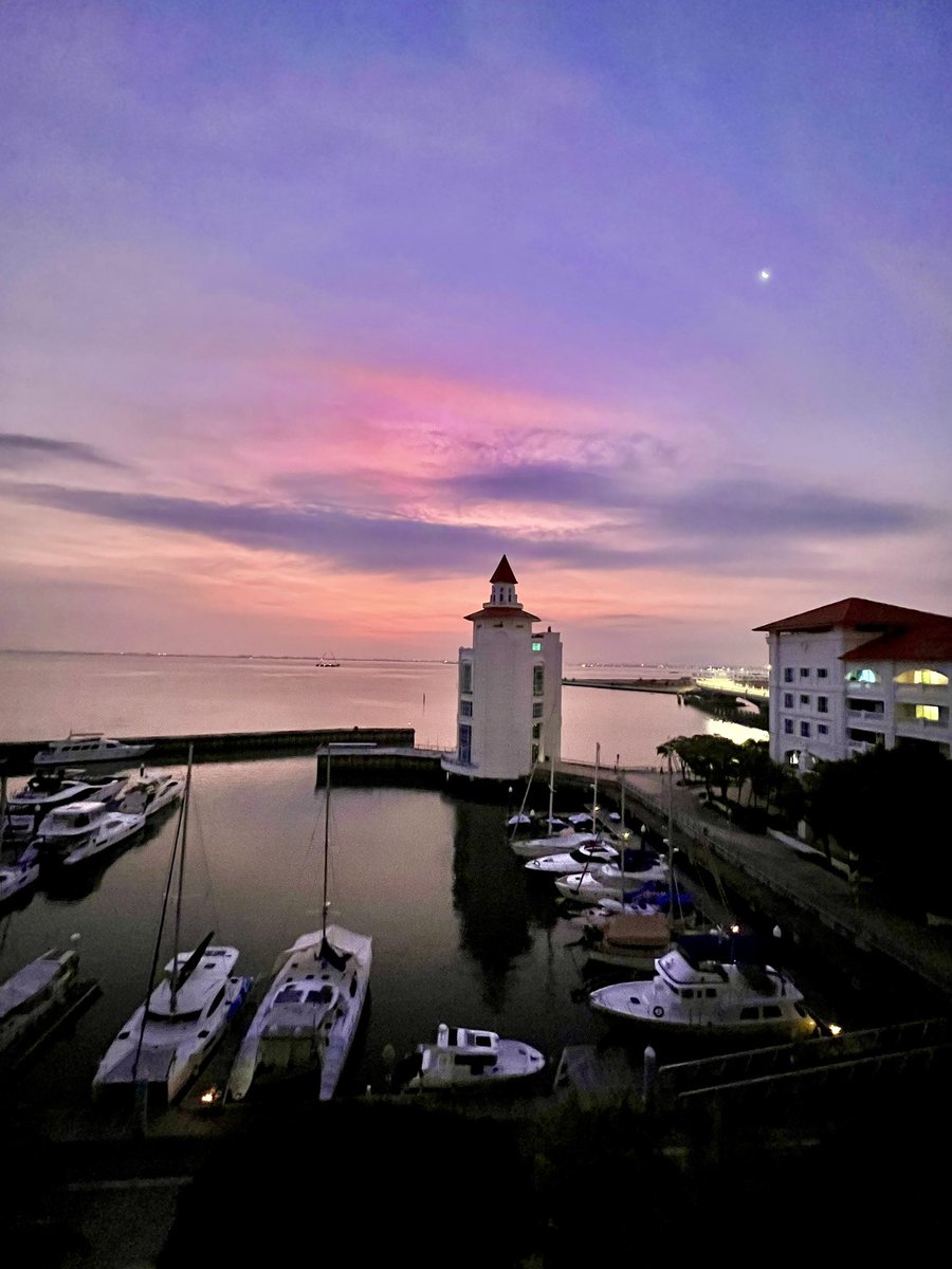 Timing is everything. I caught the☀️peeking out as the🌛was about to retire into the clouds.  The exchange turned the skies into a beautiful and striking shade of magenta blue.

Sun, moon, sea at Straits Quay, Penang.