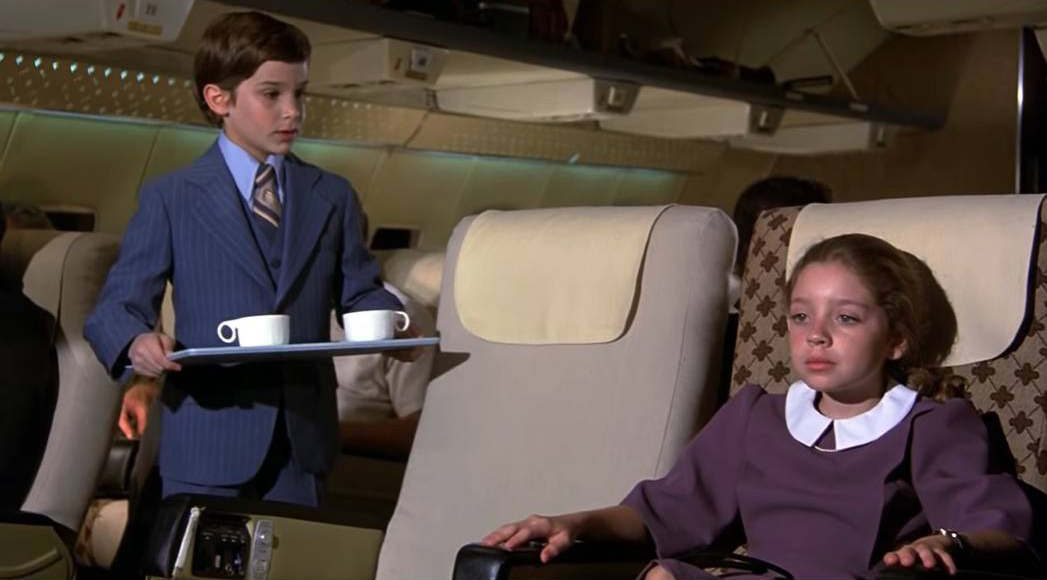 coffee kid from Airplane wears a better suit than 99% of men today